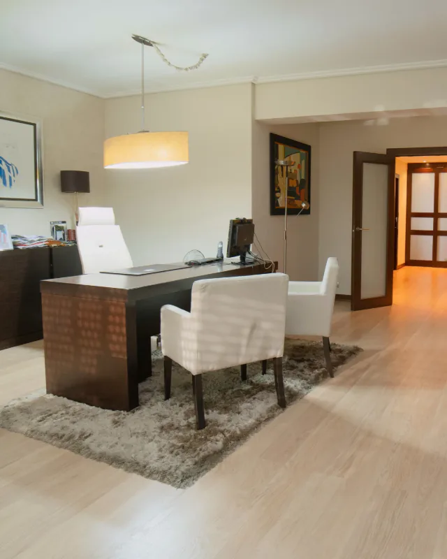 Despacho de dirección, con la mesa de trabajo y las butacas de visita